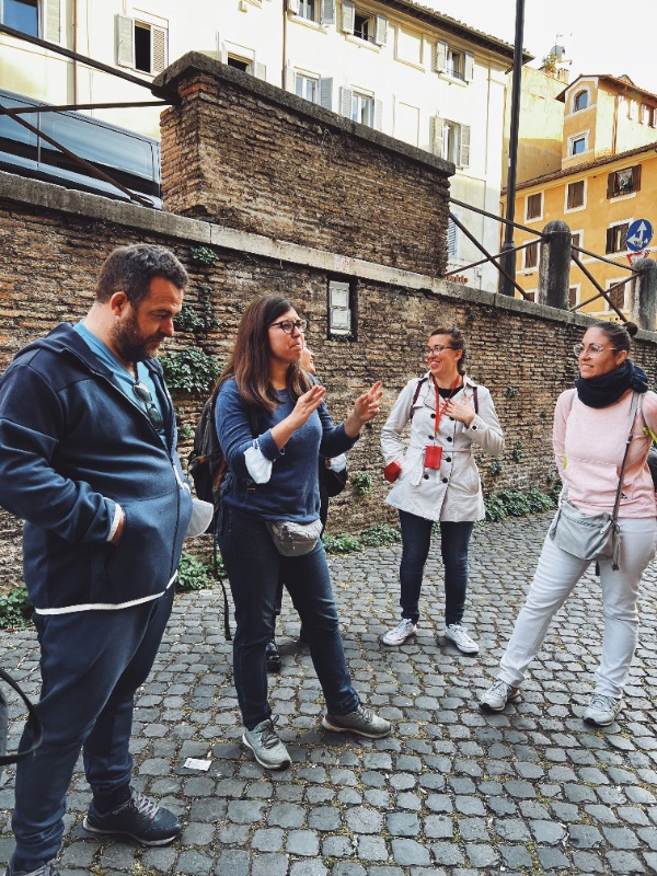 Due guide turistiche spiegano il motivo della visita a un gruppo di persone
