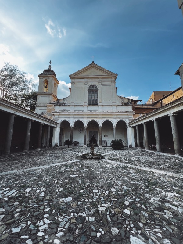 Foto dell'ingresso della Basilica di San Clemente a Roma con chiostro interno e colonnato laterale